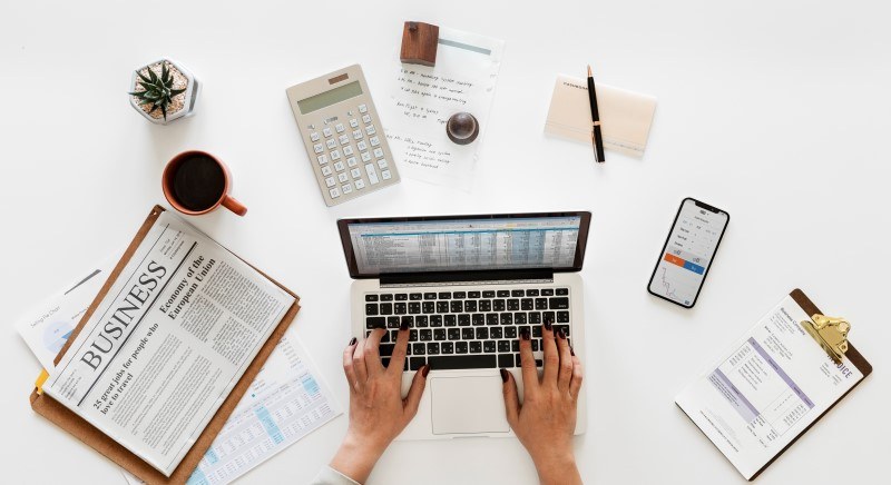 Bookkeeping paperwork and a laptop on a desk